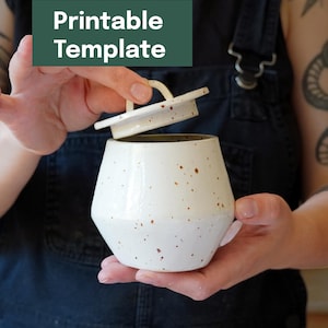 Peut inclure: Un pot en céramique blanc avec un couvercle, parsemé de taches brunes. Le pot a une forme géométrique et est maintenu ouvert, révélant l'intérieur. Le texte "Printable Template" est dans un rectangle vert en haut à gauche.