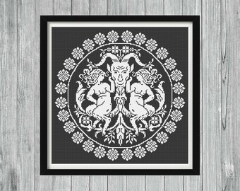 May include: Black and white cross-stitch pattern featuring a goat head with horns and two figures flanking the head. The design is surrounded by a circle of white flowers.
