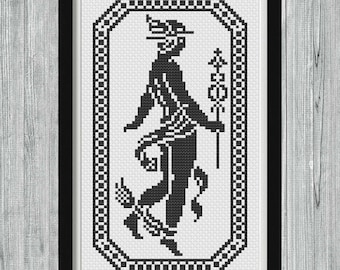 May include: Black and white cross-stitch pattern of a stylized figure in a frame. The figure is wearing a hat and holding a staff. The frame has a geometric design.