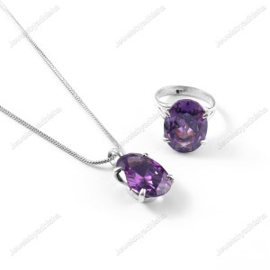 Könnte beinhalten: Ein silbernes Halsketten- und Ringset mit einem großen ovalen, violetten Edelstein. Die Halskette hat eine zarte Kette und der Ring hat eine schlichte Band.