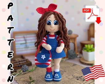 May include: Crochet doll pattern in PDF format. The doll is wearing a blue and white striped shirt, a blue denim overall dress, and a red headband. She is holding a blue and red striped bag with a white star.