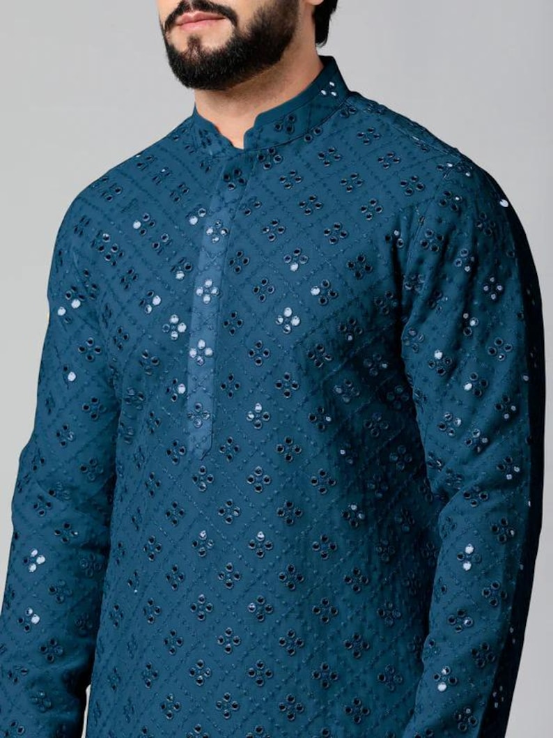 Puede incluir: Una kurta azul turquesa con un dise&ntilde;o tradicional bordado con peque&ntilde;os espejos redondos.
