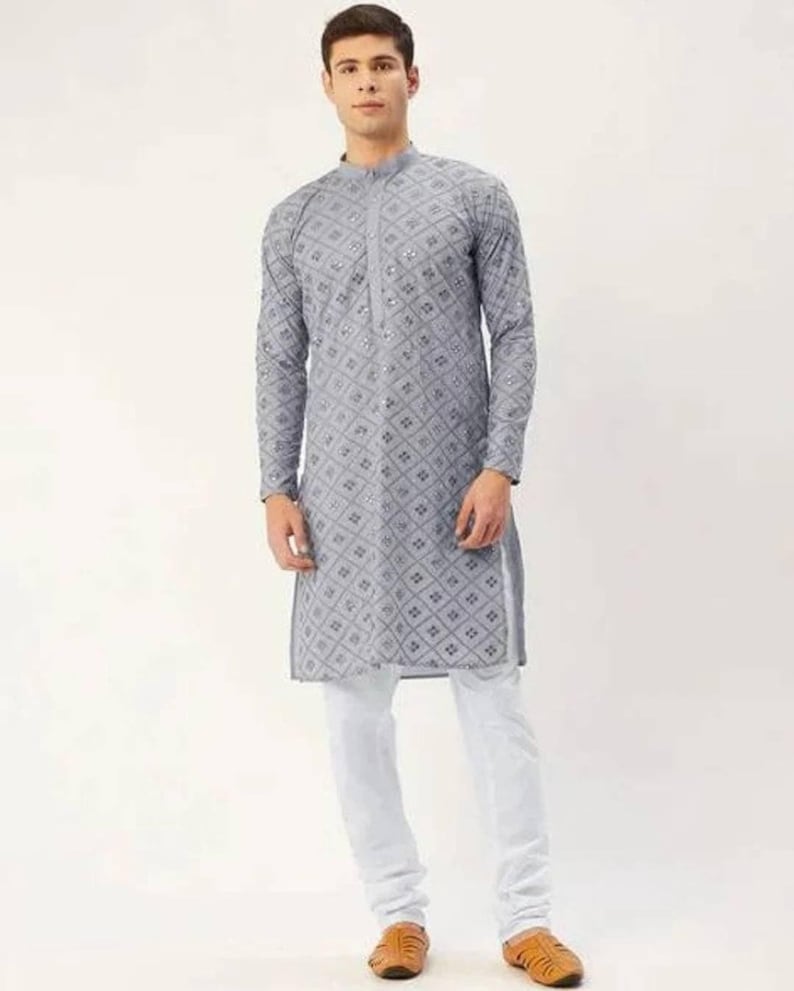 Puede incluir: Una kurta gris de manga larga con un patr&oacute;n geom&eacute;trico y adornos plateados. La kurta tiene un cuello mandar&iacute;n y un cierre de bot&oacute;n. El modelo lleva pantalones blancos y sandalias marrones.