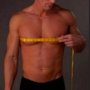 Puede incluir: Un hombre mide su pecho con una cinta m&eacute;trica amarilla. Lleva pantalones cortos de boxeo negros.