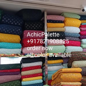 Puede incluir: Una pared de exposici&oacute;n de telas coloridas con una variedad de patrones y texturas. La tela est&aacute; apilada en filas y est&aacute; disponible en una variedad de colores, incluyendo amarillo, azul, verde, rojo y rosa. El texto "AchicPalette +917821908825 order now all color available" es visible en la pared.