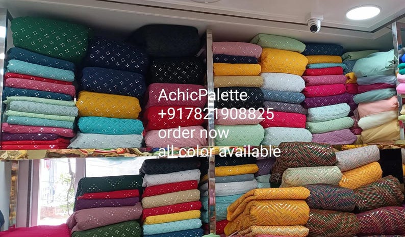Puede incluir: Una pared de exposici&oacute;n de telas coloridas con una variedad de patrones y texturas. La tela est&aacute; apilada en filas y est&aacute; disponible en una variedad de colores, incluyendo amarillo, azul, verde, rojo y rosa. El texto "AchicPalette +917821908825 order now all color available" es visible en la pared.