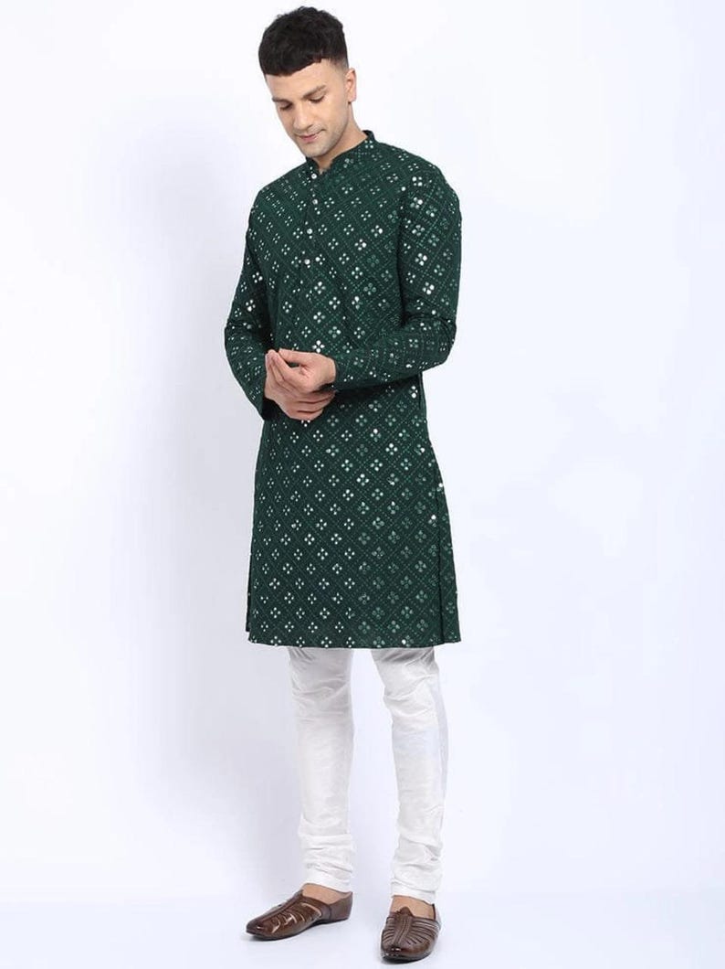 Puede incluir: Una kurta verde de manga larga con un patr&oacute;n geom&eacute;trico blanco y verde. La kurta tiene un cuello mandar&iacute;n y un cierre de bot&oacute;n. El modelo lleva pantalones blancos y zapatos marrones.