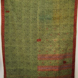 Puede incluir: Un edredón estampado en verde y rojo. El edredón presenta un diseño floral repetido en negro sobre un fondo verde. El borde es rojo liso. También hay rayas horizontales rojas y rosas y detalles florales rojos.