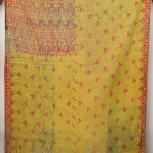 May include: A rectangular textile featuring a patchwork design with a dominant yellow base color. The fabric displays various patterns including small red floral motifs, leaf shapes, and geometric borders in shades of red and orange.