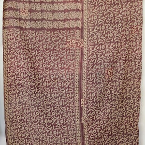 Könnte beinhalten: Bordeauxfarbener und beigefarbener Stoff mit floralem Muster. Der Stoff hat einen gestreiften Rand und einen vertikalen Mittelstreifen. Das florale Muster wiederholt sich über den Stoff und erzeugt ein detailliertes Design.