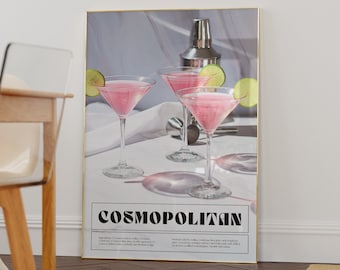 May include: A poster with a gold frame featuring a photograph of three pink cocktails with lime wedges. The poster has the text "COSMOPOLITAN" in bold black letters and includes the ingredients and method for making the cocktail.