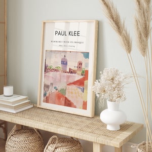 May include: A framed print of a watercolor painting by Paul Klee titled "Hammamet with its Mosque" from 1914. The painting depicts a colorful cityscape with a mosque in the background.