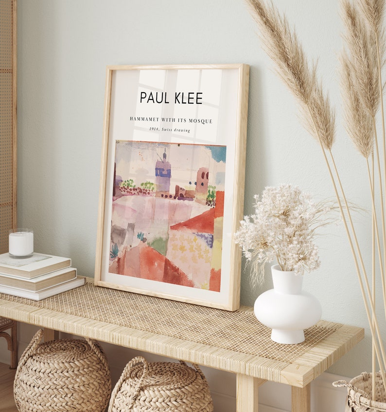 May include: A framed print of a watercolor painting by Paul Klee titled "Hammamet with its Mosque" from 1914. The painting depicts a colorful cityscape with a mosque in the background.