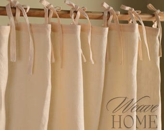 May include: A set of off-white linen curtains with a simple design and tied with fabric loops. The curtains are hung on a wooden rod. The text "Weave Home" is visible in the lower right corner of the image.
