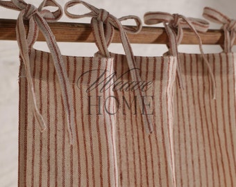 May include: A set of three cream-colored curtains with thin red stripes and matching ties. The curtains are hung on a wooden rod.