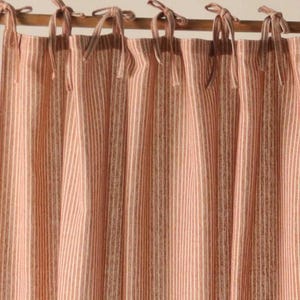 May include: Red and white striped curtains with a simple tie-top design. The curtains are made of a lightweight fabric and have a subtle sheen.