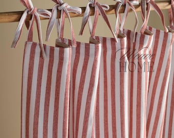 May include: Red and white striped curtains with a tie-top design. The curtains are made of a soft, woven fabric and have a casual, farmhouse style.