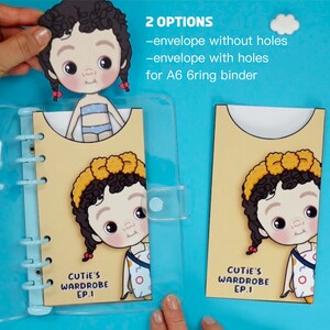 Op de afbeelding: Een lichtblauw A6 ringband met twee gele enveloppen met een cartoonmeisje. De enveloppen hebben de tekst "CUTIE'S WARDROBE EP.1" en de afbeelding toont twee opties: &eacute;&eacute;n zonder gaten en &eacute;&eacute;n met gaten.