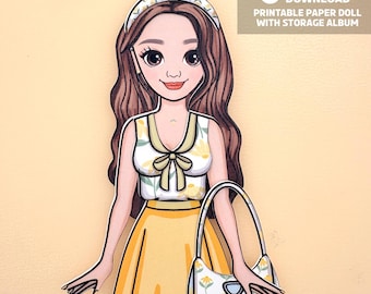 Op de afbeelding: Papieren poppenillustratie van een vrouw in een gele rok en bloemen top, met een bijpassende handtas. De pop heeft lang bruin haar en een hoofdband. Tekst op de afbeelding luidt "Direct downloaden Printbare papieren pop met opbergalbum."