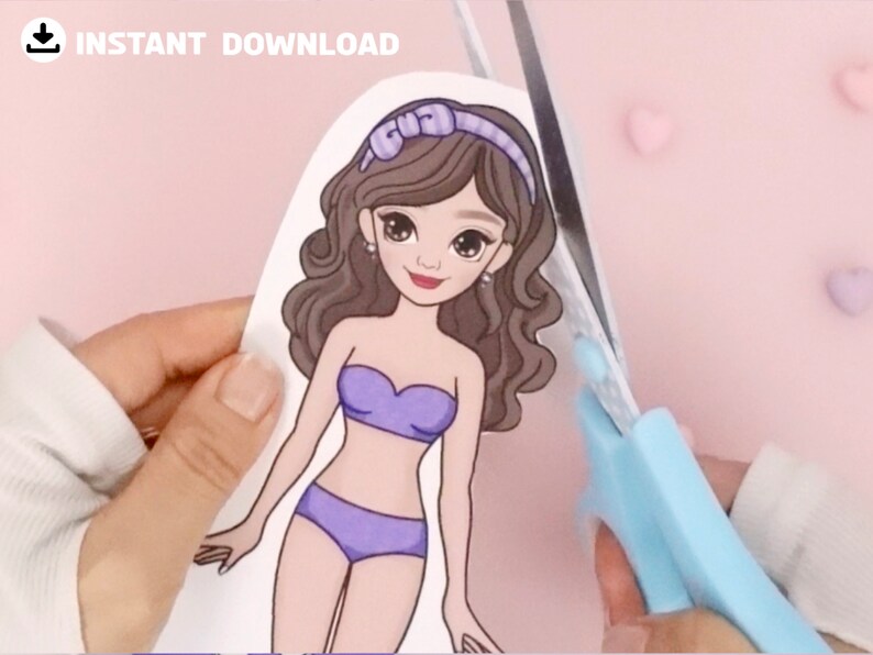 May include: A paper doll cutout of a girl with brown hair, wearing a purple bikini top and bottom. The doll is being cut out with blue scissors.