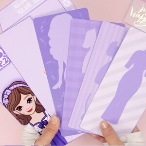 May include: A set of purple paper cutouts featuring different dress silhouettes. The cutouts are on a light purple background with a white striped pattern. The text "ROS! EP.2" is visible in the top left corner of the image.