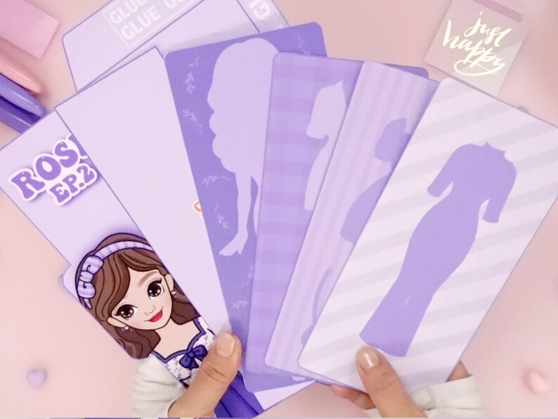 May include: A set of purple paper cutouts featuring different dress silhouettes. The cutouts are on a light purple background with a white striped pattern. The text "ROS! EP.2" is visible in the top left corner of the image.