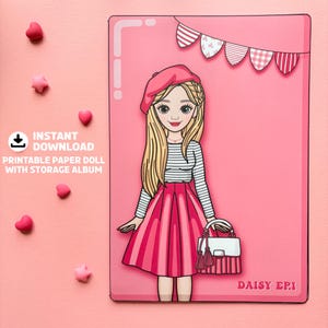 May include: A pink paper doll with a beret, striped shirt, and pink skirt, holding a purse. The doll is inside a pink frame with decorative elements. Text reads "Instant Download Printable Paper Doll With Storage Album."