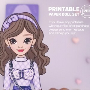 May include: Printable paper doll set featuring a cartoon girl with brown hair wearing a purple and white checkered top, a purple headband with a bow, and a silver chain necklace. The text "PRINTABLE PAPER DOLL SET" and "PDF" are visible in the image.