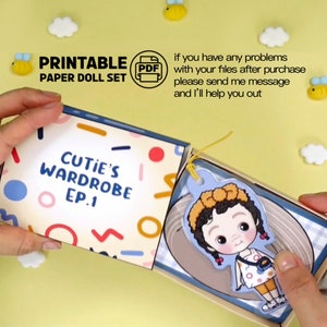 Op de afbeelding: Een open, afdrukbare papieren poppenset met de titel "Cutie's Wardrobe EP.1" toont een papieren pop met een gele haaraccessoire en een kleine handtas. De doos is versierd met kleurrijke vormen en de tekst "Printable Paper Doll Set".