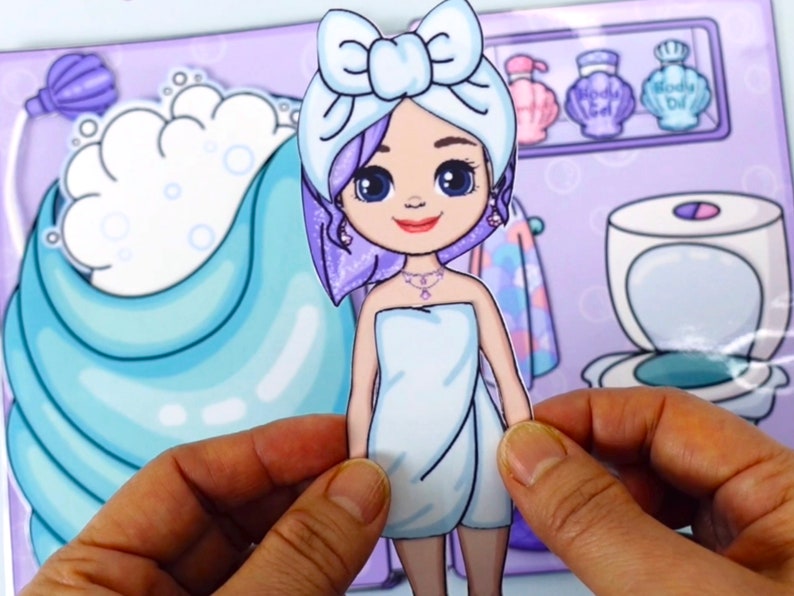 May include: A paper doll of a girl in a spa setting. The doll is wearing a white towel and a bow on her head. The background features a bathtub, toiletries, and a toilet, all in a cartoon style.