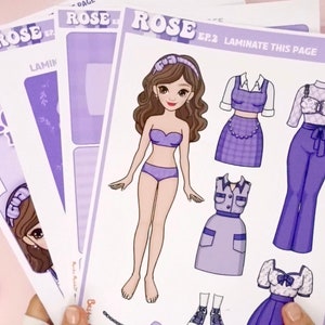 May include: A paper doll set featuring a girl with brown hair and purple outfits. The set includes a variety of clothing options, including a dress, a skirt, and a top. The paper doll set is printed on white paper with a purple background. The text "ROSE EP.2 LAMINATE THIS PAGE" is printed on the page.