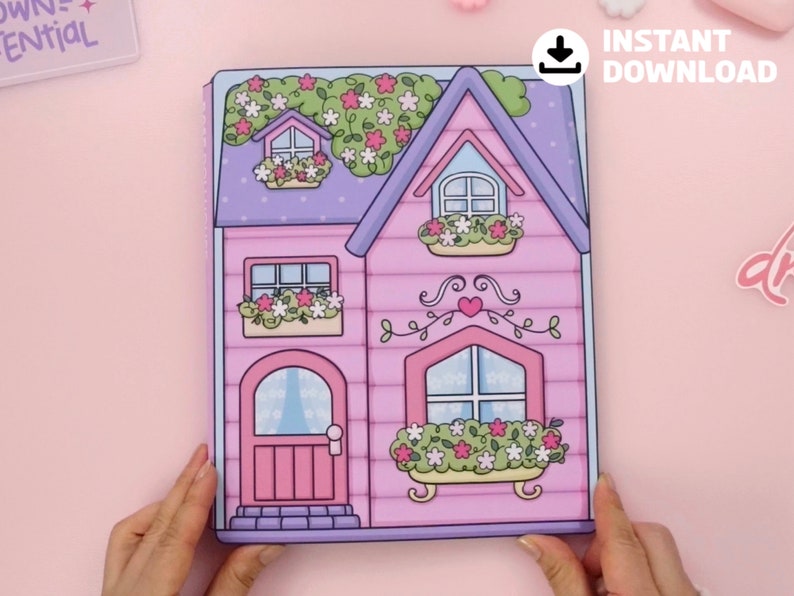 Op de afbeelding: Een roze en paars papieren poppenhuis met een bloemenontwerp. Het poppenhuis heeft een deur, ramen en een dak met een klein raam. De afbeelding bevat de tekst "INSTANT DOWNLOAD".