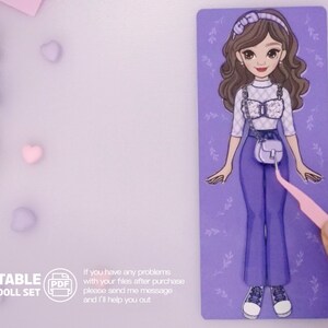May include: Printable paper doll set featuring a cartoon girl with brown hair wearing a white and black checkered top, blue jeans, and a light blue handbag. The doll is on a purple background with floral accents.