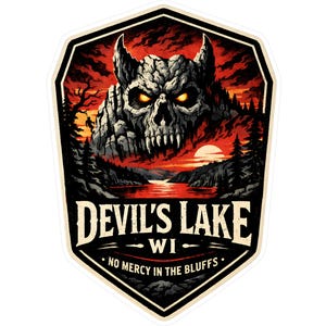 May include: A sticker featuring a detailed illustration of a skull-shaped mountain with glowing yellow eyes, set against a fiery red sky. The text "DEVIL'S LAKE WI" and "NO MERCY IN THE BLUFFS" are displayed below the image.