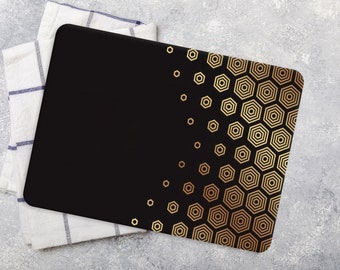 Peut inclure: Set de table de couleur noire avec un motif géométrique hexagonal doré. Le set de table est posé sur une serviette de cuisine à carreaux blancs et bleus.