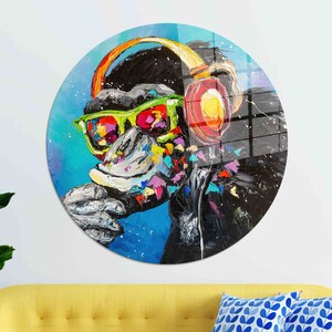 Peut inclure: Une peinture colorée d'un singe portant un casque et des lunettes de soleil. Le singe est peint dans un style vibrant avec des éclaboussures de couleur et de texture. L'arrière-plan est un motif abstrait bleu et blanc.
