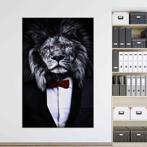 May include: A black and white photo of a lion wearing a tuxedo and a red bow tie. The lion is wearing glasses and has a serious expression on its face.