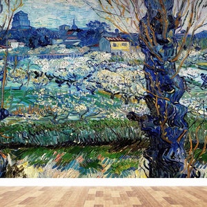 Puede incluir: Una pintura de un paisaje con un campo de flores blancas y árboles en primer plano. Los árboles están pintados con una pintura espesa y azul, y las flores son de un color blanco claro. El fondo es de un azul brumoso y hay edificios en la distancia.