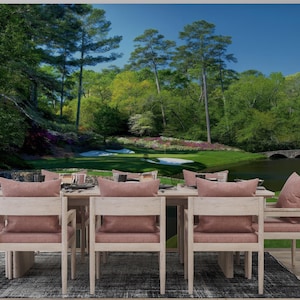 May include: A dining room set with a golf course mural. The table is set with place settings and surrounded by light wood chairs with pink cushions. The mural depicts a lush green golf course with trees, water, and a bridge.