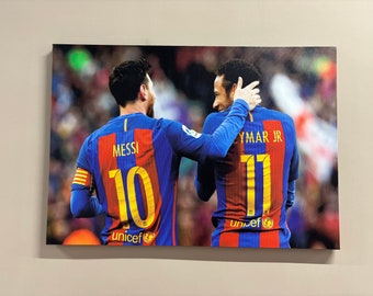 May include: Two soccer players wearing blue and red jerseys with the names "Messi" and "Neymar Jr." on the back. The players are wearing the numbers "10" and "11" on their jerseys. The jerseys have the UNICEF logo on the front.