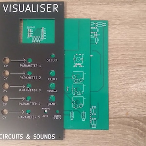 Può includere: Una scheda di circuito elettronico nera e verde con il testo "VISUALISER" e "CIRCUITS & SOUNDS". La scheda ha una varietà di pulsanti, manopole e interruttori.