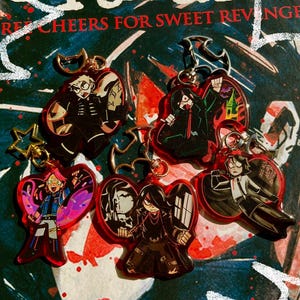 以下が含まれることがあります： アニメのキャラクターが描かれた赤いアクリルキーホルダーが5つ。それぞれのキーホルダーには、黒髪で黒服を着た異なるキャラクターが描かれています。キャラクターはさまざまなポーズをとっています。キーホルダーは、赤と白の文字が書かれた暗い背景の上に置かれています。