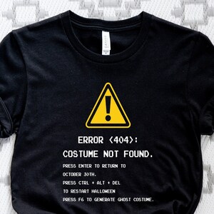 May include: Black t-shirt with a yellow warning sign and the text "ERROR <404>: COSTUME NOT FOUND."  The text below the warning sign reads "PRESS ENTER TO RETURN TO OCTOBER 30TH. PRESS CTRL ALT DEL TO RESTART HALLOWEEN PRESS F6 TO GENERATE GHOST COSTUME."