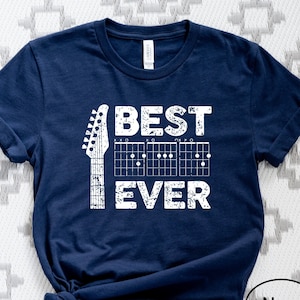 May include: Navy blue t-shirt with a white graphic of a guitar and the text "BEST EVER".