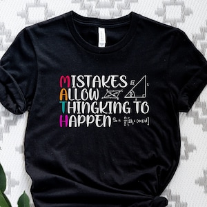 May include: Black t-shirt with white text that reads "MATH Mistakes Allow Thinking To Happen" with a math equation and geometric shapes.