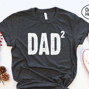 May include: Dark grey heather t-shirt with the text "DAD²" in white.