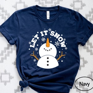 May include: A navy blue t-shirt with a white snowman graphic and the text "Let it Snow".