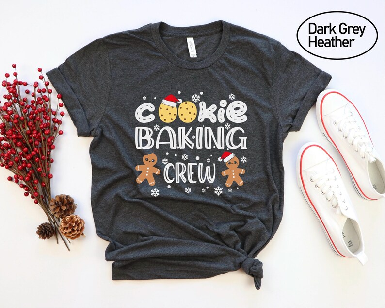 May include: Dark grey heather t-shirt with the text "Cookie Baking Crew" and a gingerbread man and cookie graphic.