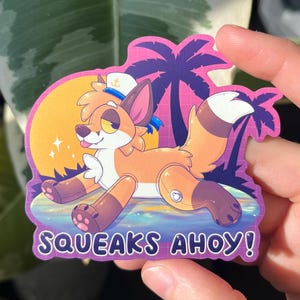 May include: A colorful sticker featuring a cartoon fox in a sailor hat, set against a tropical sunset with palm trees. The sticker has the text "SQUEAKS AHOY!" in white letters.