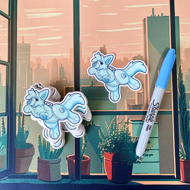 Op de afbeelding: Een stapel lichtblauwe wolf stickers met een witte omtrek. De stickers liggen op een tafel met een raam op de achtergrond. Het raam heeft uitzicht op een skyline van de stad. Er ligt een blauwe Sharpie fijne punt stift op de tafel.